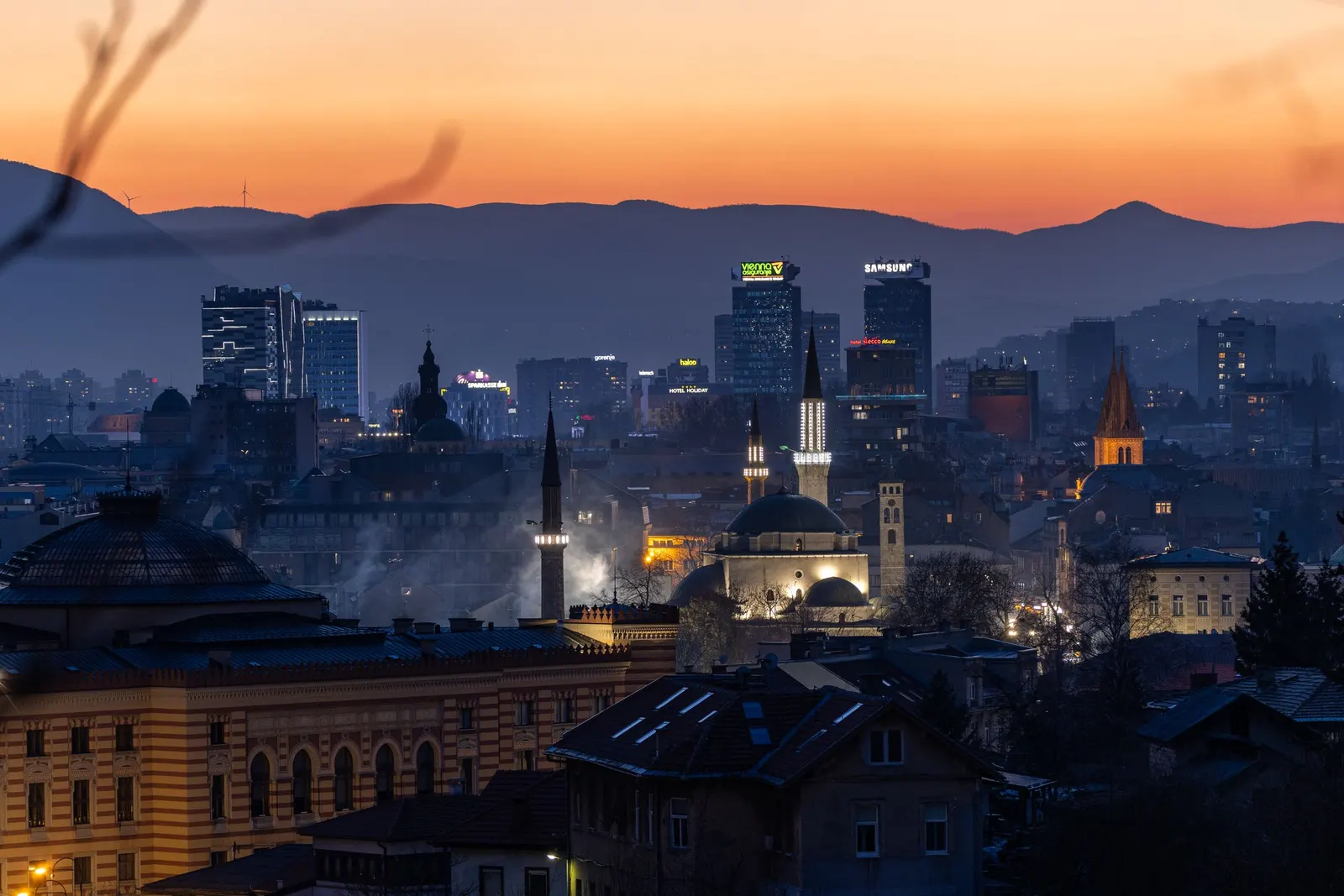 Sarajevo at dusk, with the mountains behind the city